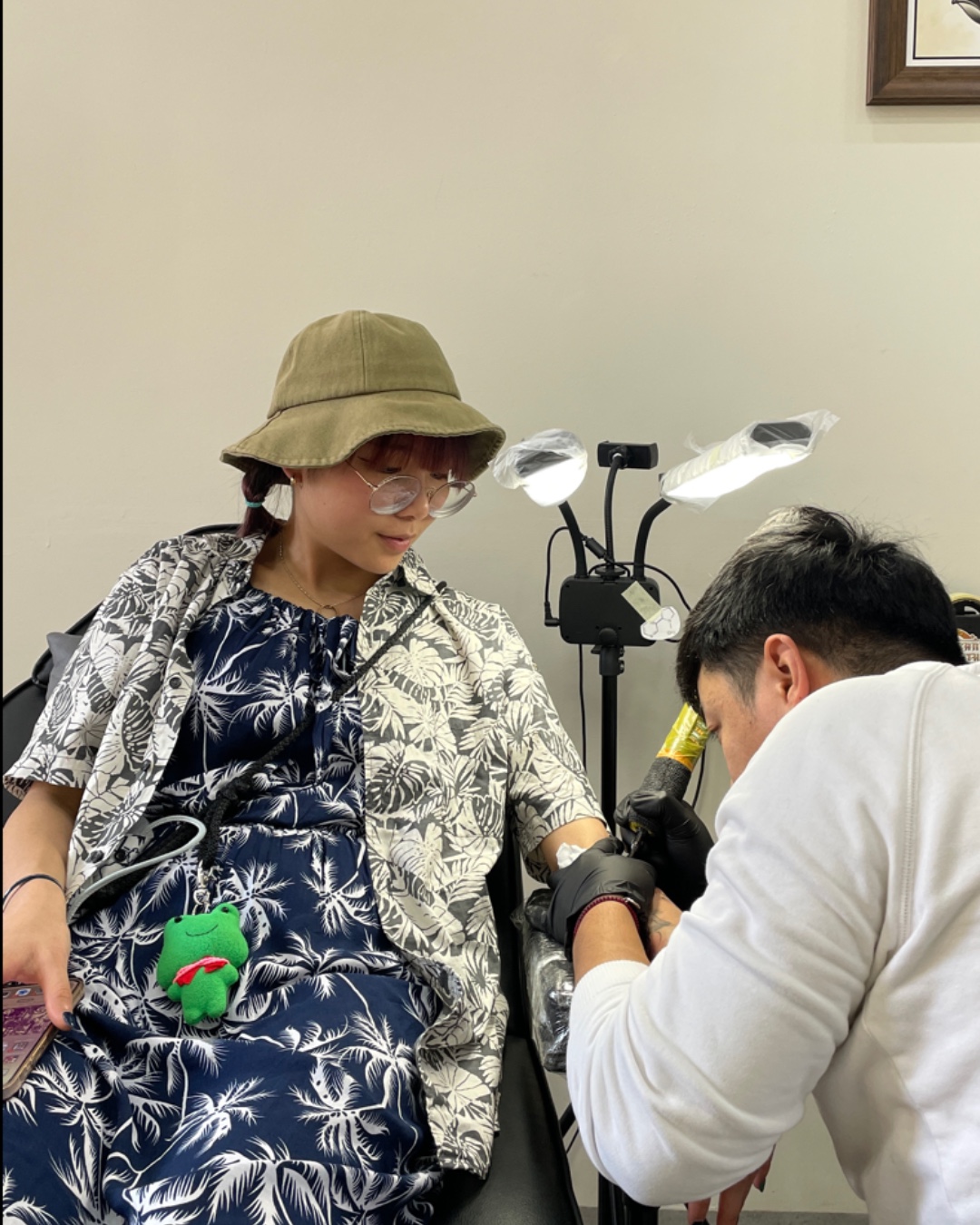 A tattoo artist carefully working on a client’s arm at a Tattoo Studio in Da Nang, showcasing expert craftsmanship and attention to detail.